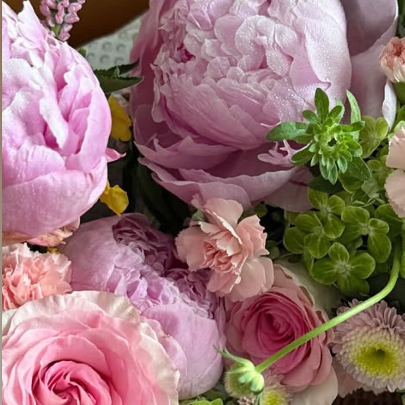 Close-up of peonies and roses in a Fleurtatious arrangement